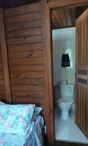 a bathroom with a toilet and a bed in a room at Brayan`s House in Ilha do Mel