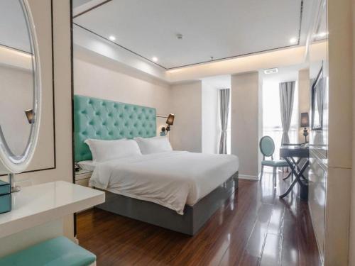 Un dormitorio con una cama con cabecero azul y un espejo. en Xana Lite Anqing Yuexi Swan Squre Branch, en Yuexi