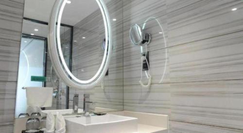 a bathroom with a sink and a mirror at Xana Hotelle Neijiang City Center Branch in Neijiang