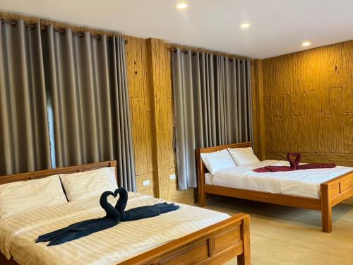 Dos camas en una habitación con dos en PhuMan Resort & Cafe Phetchaburi, en Ban Wang Malako