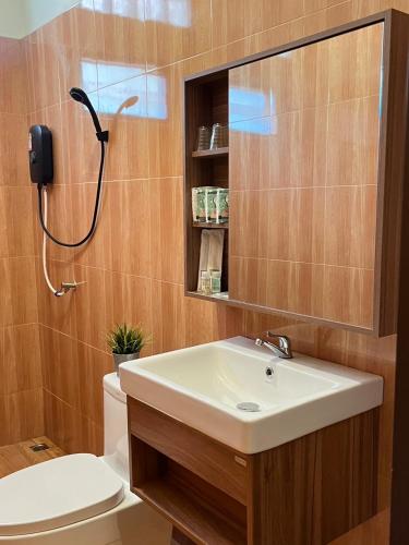 a bathroom with a sink and a toilet and a mirror at PhuMan Resort & Cafe Phetchaburi in Ban Wang Malako