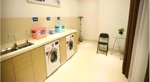 a laundry room with a sink and a washing machine at City Comfort Inn Shenzhen International Exhibition Center Tangwei Metro Station in Shenzhen