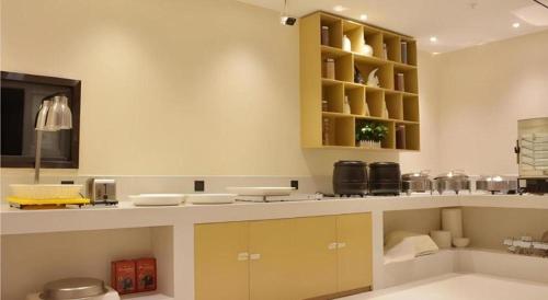 a kitchen with yellow cabinets and a counter at City Comfort Inn Baise Longlin Yingbin Road in Lengshui
