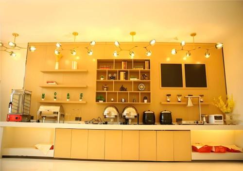 a kitchen with yellow walls and a large counter top at City Comfort Inn Xiaogan Xiaochang Bus Passenger Station in Xiaogan