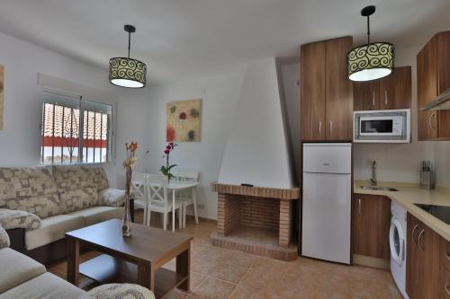 a kitchen and living room with a couch and a table at Apartamentos El Madroñal in Coto Rios