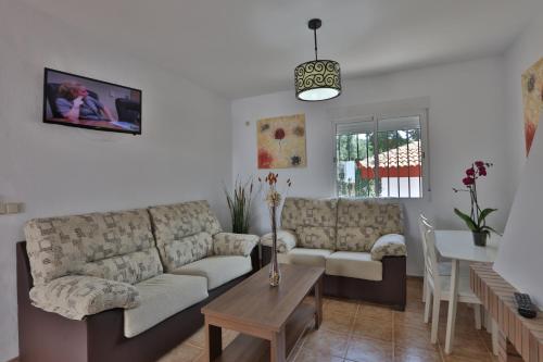 a living room with a couch and a table at Apartamentos El Madroñal in Coto Rios