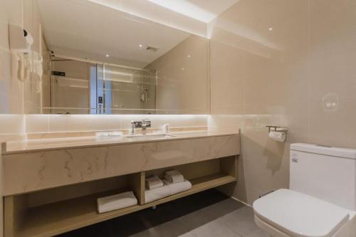 a bathroom with a sink and a toilet and a mirror at City Comfort Inn Foshan Gaoming Huaying Square in Foshan