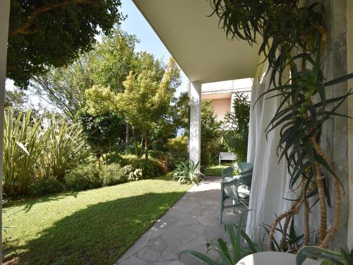a patio with a chair and a grass yard at Chalet by Lake Maggiore with Garden Views in Verbania