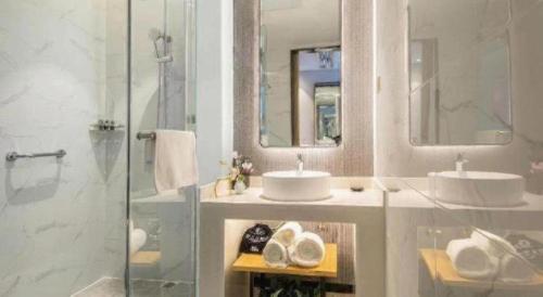 a bathroom with two sinks and a shower at Magnotel Tongxiang Shimao Center in Jiaxing