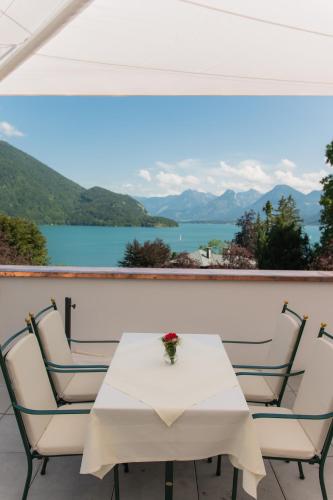 a table and chairs with a view of the water at Seehotel Billroth in Sankt Gilgen