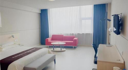 a room with a bed and a couch and a tv at Jinjiang Inn Hengshui Anping in Anping