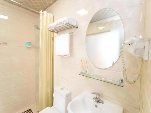 a bathroom with a sink and a mirror at Shell Hotel Yangzhou Yangzijiang Bei Road Slender West Lake Scenic Area in Yangzhou