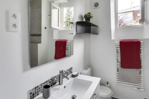 uma casa de banho branca com um lavatório e um espelho em Fontainebleau Sweet Home em Fontainebleau