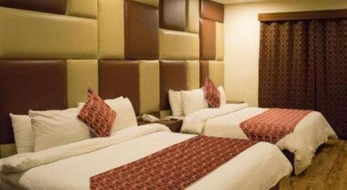 ラホールにあるHotel Grand Millenniumの部屋にベッドが2つあるホテルの部屋