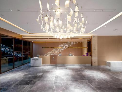 潮州市にあるLavande Hotel Chaozhou Fortune Center Lin Streetの建物内の大きなシャンデリアのあるロビー