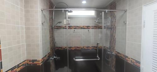 a bathroom with a shower with a glass door at Pattaya Beach View Talay 6 by AEGEAN Suite Condo in Pattaya Central