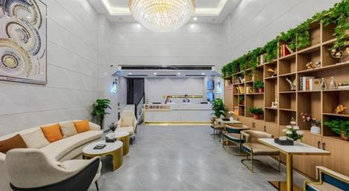 a waiting room with couches and tables and plants at Green Tree Inn Express Heze University Town in Heze