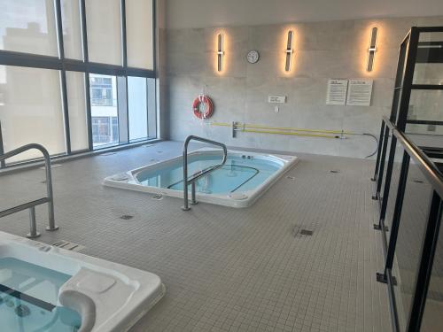 キッチナーにあるLuxury Condo with Hottub, outdoor firepit & Bowlinの洗面台2つとバスタブ付きのバスルーム