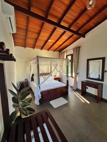 a bedroom with a bed with a canopy at Stay199 in Haragama