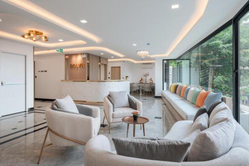a living room with two couches and a table at Solyn Hotel in Bangkok
