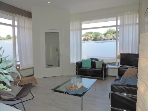 a living room with a couch and a table at Sea & Dunes in Scheveningen