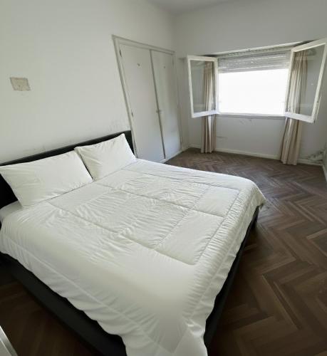a white bed in a room with a window at Check and Home - Peatonal II - 6 Huéspedes en el Centro a 3 cuadras de la Playa in Mar del Plata