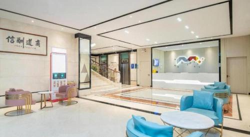 a living room with blue chairs and a table at Borrman Hotel Dongguan Houjie Wanda Plaza Liaoxia Metro Station in Dongguan