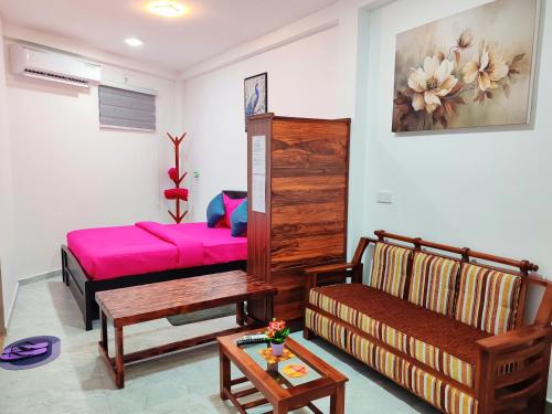 a living room with a pink bed and a couch at ANTONIO TRANSIT KATUNAYAKE in Katunayaka