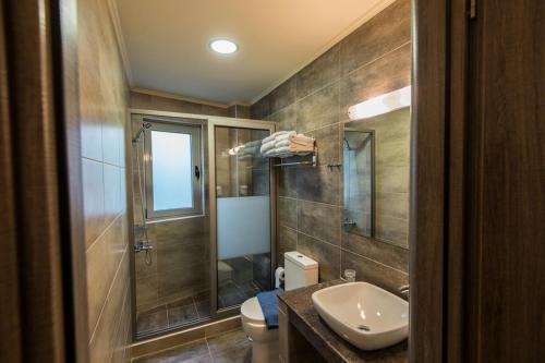 Harmony Hotel في كوروتا: حمام مع مرحاض ومغسلة ودش