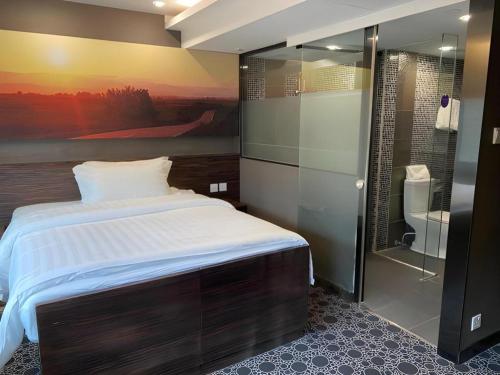 a bedroom with a large bed and a bathroom at J Link Hotel in Hong Kong