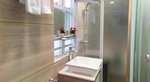 a bathroom with a shower and a white sink at Metroplace Boutique in Hong Kong