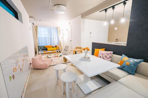 eine Küche und ein Wohnzimmer mit einem weißen Tisch und Stühlen in der Unterkunft Otter Stay - Takaoka in Aoichō