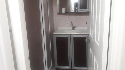 een badkamer met een wastafel, een spiegel en een deur bij Simal Butik Hotel in Izmir