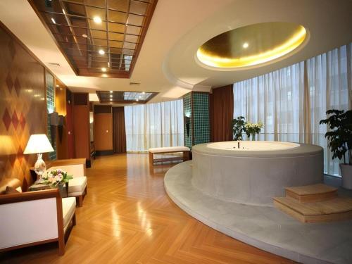 運城市にあるYuncheng Jianguo Hotelの建物の中央に大きなバスタブ付きのロビー