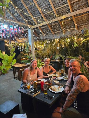 a group of people sitting at a table in a restaurant at Surf reef beach in Trincomalee