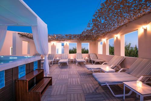 a patio with chairs and a swimming pool at night at Omiros Boutique Hotel (Adults Only) in Rethymno