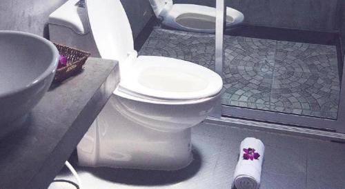 une salle de bain avec toilettes et lavabo dans l'établissement V Valley Resort, à Satun