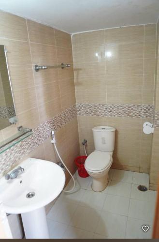 a bathroom with a white toilet and a sink at Water Paradise Resort in Cox's Bazar