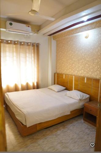 a bedroom with a large bed with white sheets at Water Paradise Resort in Cox's Bazar