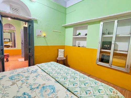 a bedroom with a bed and a chair in it at Divine Stay- Only Prime Property In Front Of The Krishnas Birthplace Janambhumi Temple, Food-Shopping-Transport All At Your Doorstep in Mathura