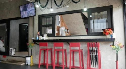 a bar with four red stools in front of a counter at 41Studio in Nakhon Phanom
