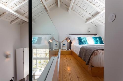una camera da letto con un letto con cuscini blu di Seventyset Flats - Porto Historical Center a Porto