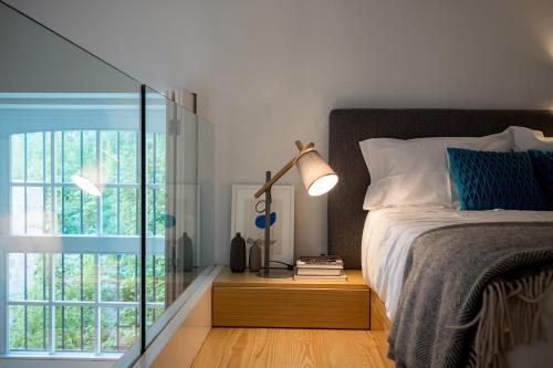 a bedroom with a bed and a glass door at Seventyset Flats - Porto Historical Center in Porto