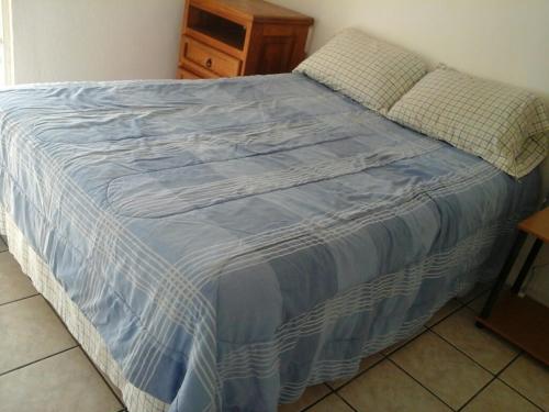 Una cama con un edredón azul y blanco. en Exhaciendas Puerto Vallarta, en Puerto Vallarta