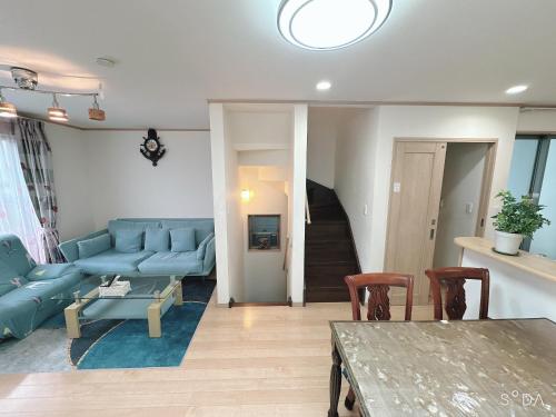 a living room with a blue couch and a table at 新規OPEN8割！1棟貸切・10名可能！秋葉原まで13分、新宿まで32分／スカイツリー近く in Tokyo