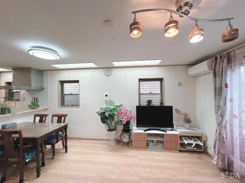 a living room with a television and a dining room table at 新規OPEN8割！1棟貸切・10名可能！秋葉原まで13分、新宿まで32分／スカイツリー近く in Tokyo