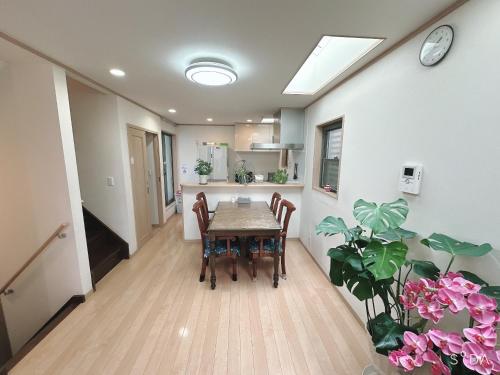 a dining room with a table and a kitchen at 新規OPEN8割！1棟貸切・10名可能！秋葉原まで13分、新宿まで32分／スカイツリー近く in Tokyo