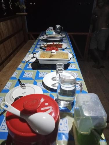 a table with a blue and white table cloth with food at Warfanin Homestay in Pulau Gam