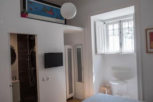 a bedroom with a bed and a window and a shower at R & Freud Guest House in Lisbon