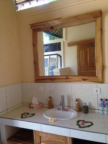 a bathroom counter with a sink and a mirror at Biorock Homestay & Dive Center Pemuteran in Pemuteran